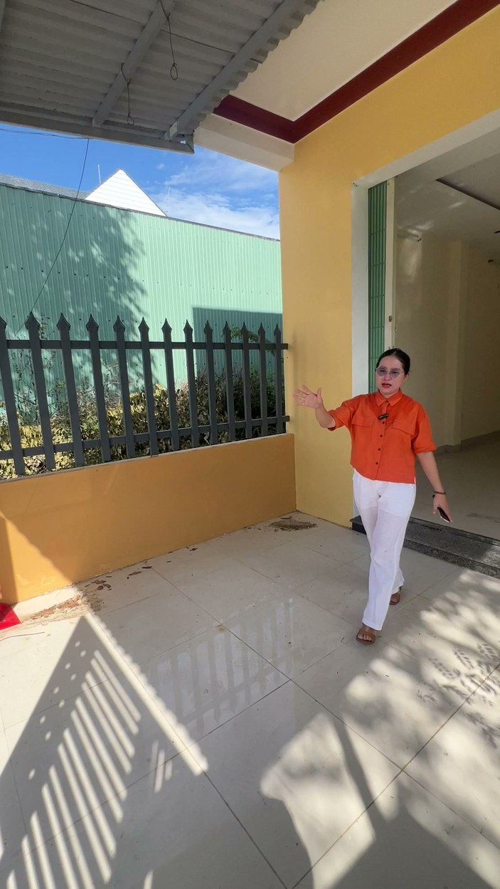 Khoảng sân và hiên trước căn nhà mặt tiền Hoàng Diệu, có cổng sắt và cửa chính vào phòng khách