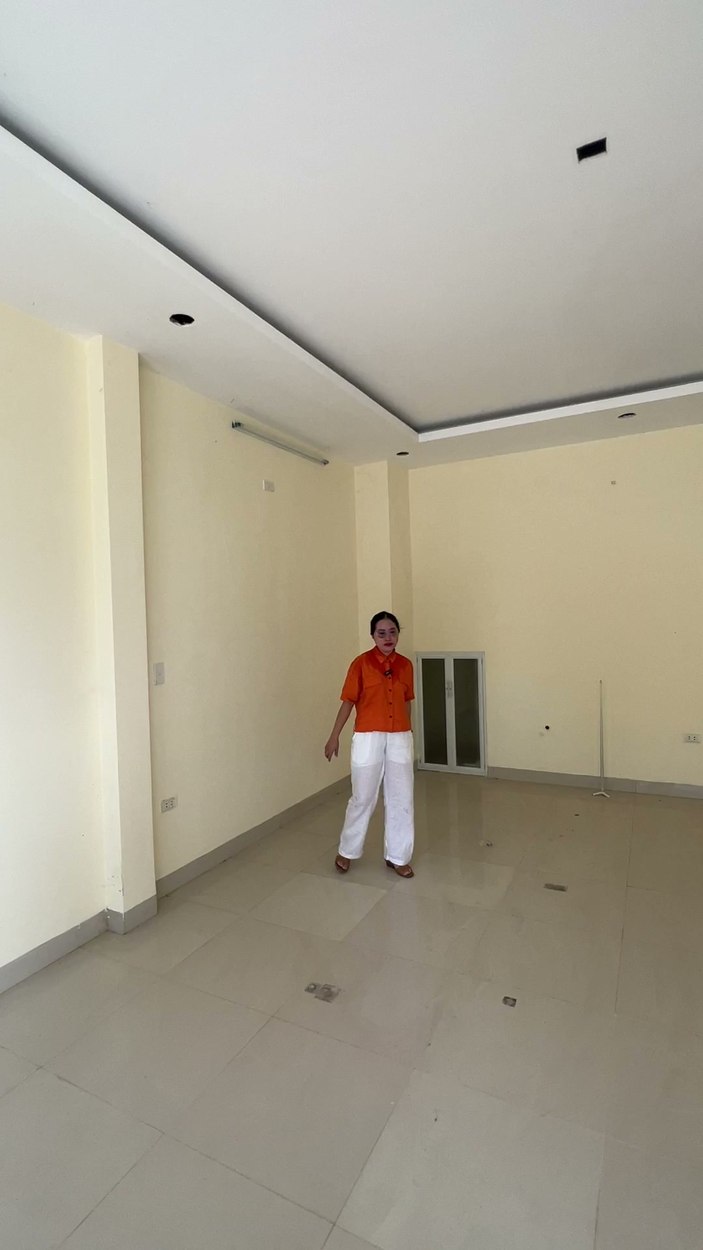 Phòng khách rộng khoảng 30m2 ở tầng 1, trần thạch cao có đèn hắt, nền lát gạch, nhà chưa có nội thất