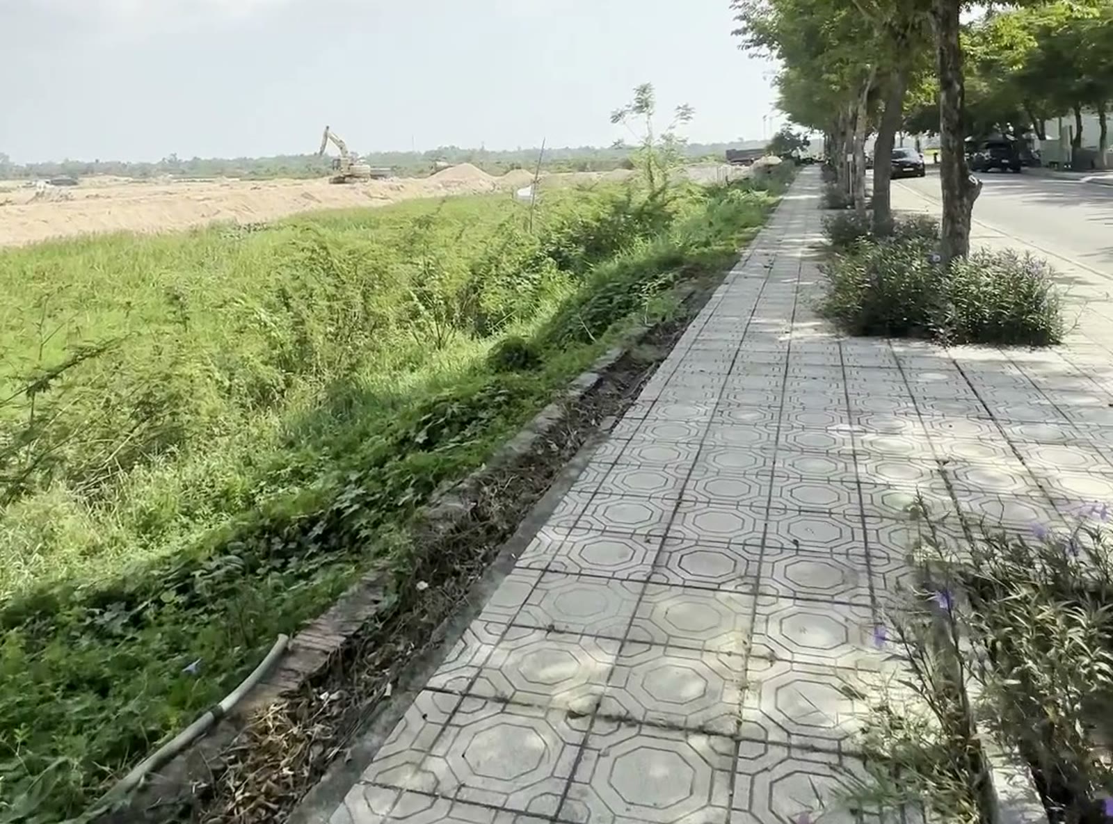 Khu đô thị Tây Bắc Tam Kỳ nhìn từ vỉa hè đường Tôn Thất Tùng, phía trong có máy múc đang san nền làm hạ tầng