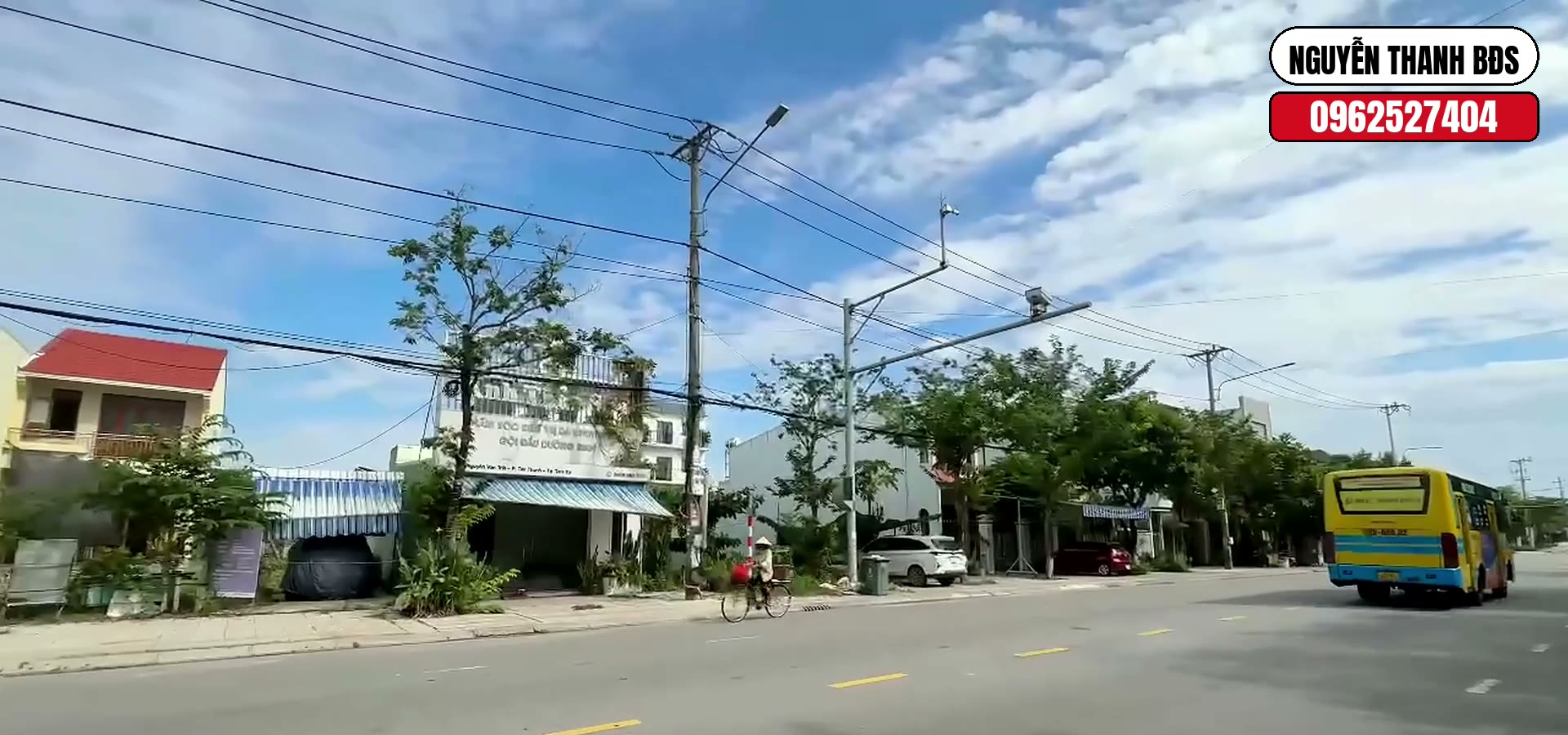 Vỉa hè rộng và lề đường trước dãy nhà trên đường Nguyễn Văn Trỗi Tam Kỳ, xe buýt chạy qua trên lòng đường