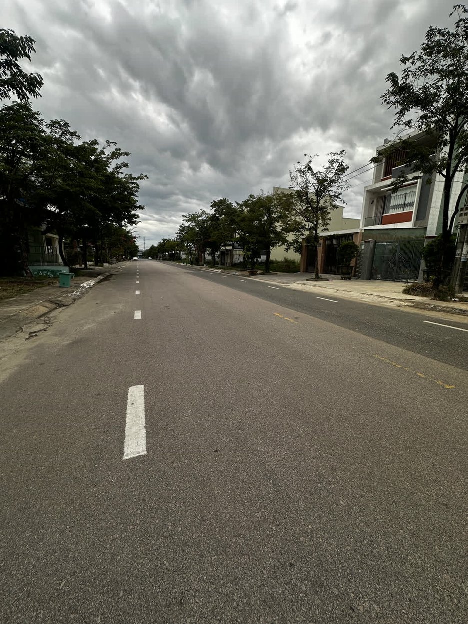 Đường Phan Khôi trước lô đất nhìn dọc, đường đã thảm nhựa kẻ vạch, hai bên có lề rộng và nhà dân đã xây