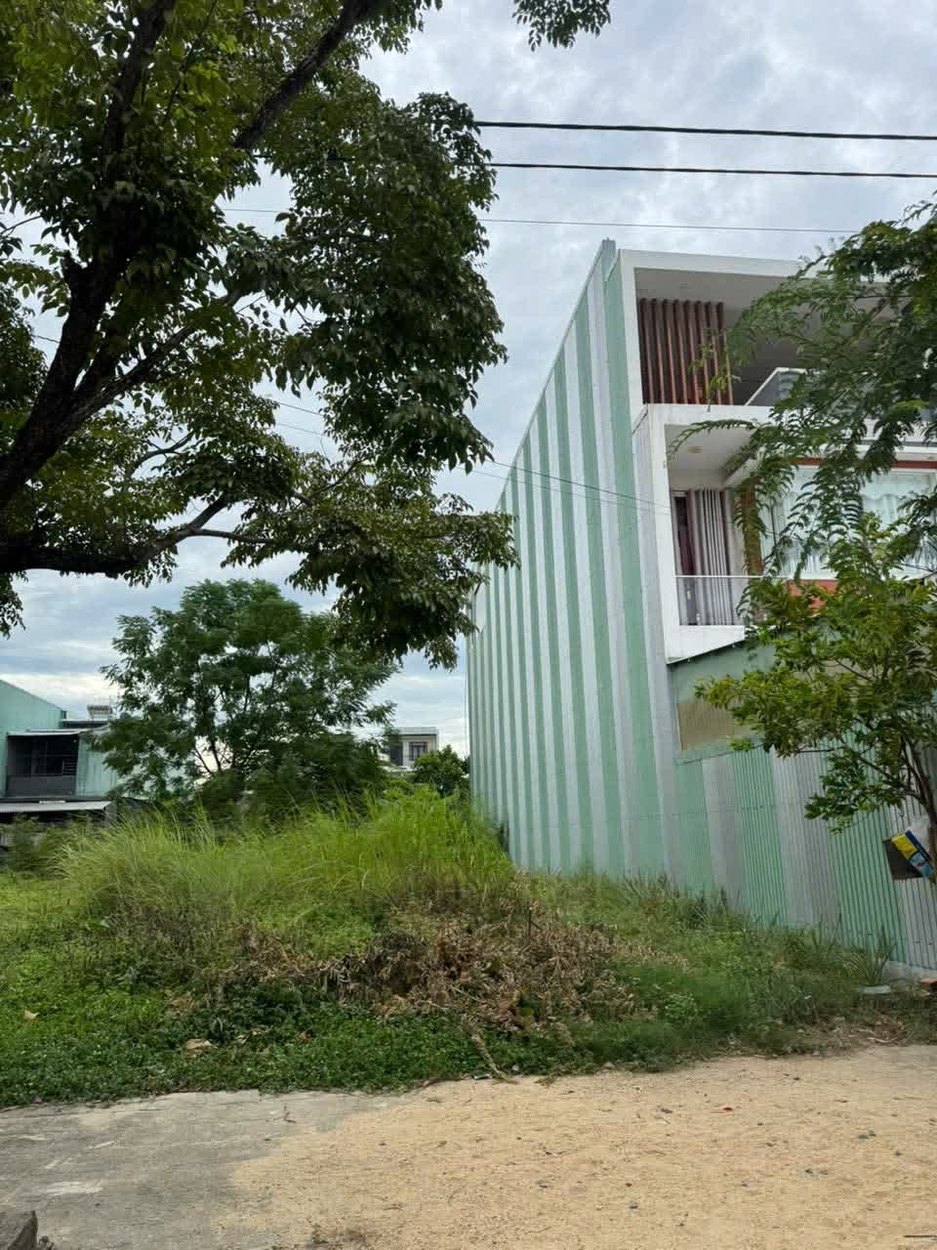 Hiện trạng lô đất trống 180m2 trên đường Phan Khôi, bên cạnh là căn nhà hai tầng đã xây xong