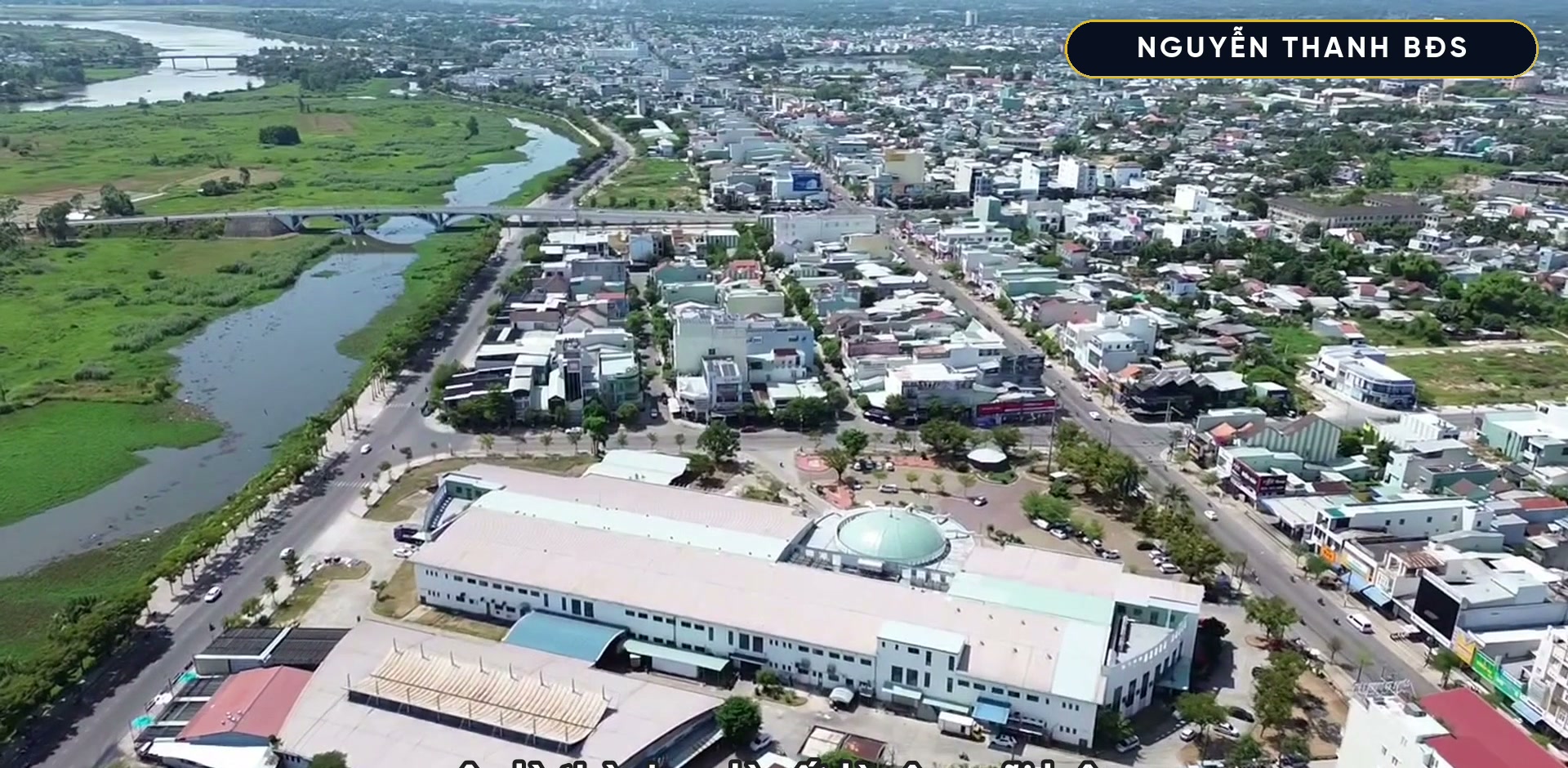 Trung tâm Tam Kỳ nhìn từ trên cao, trục đường lớn chạy giữa khu nhà dân, bên cạnh là sông và cánh đồng