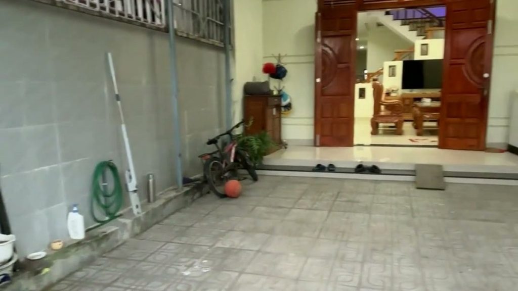 Sân có mái che trước nhà kiệt Tiểu La Tam Kỳ, nền lát gạch, nhìn vào cửa chính căn nhà