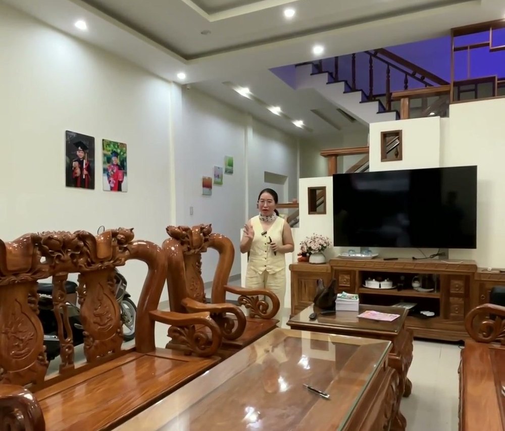 Phòng khách nhà kiệt Tiểu La Tam Kỳ với bộ bàn ghế gỗ, trần thạch cao và cầu thang phía trong