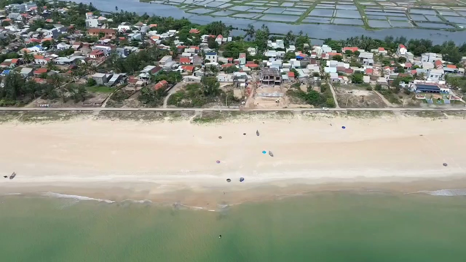 Bãi biển Tam Thanh cát rộng và thoai thoải, phía sau làng là những ô nước nuôi thuỷ sản