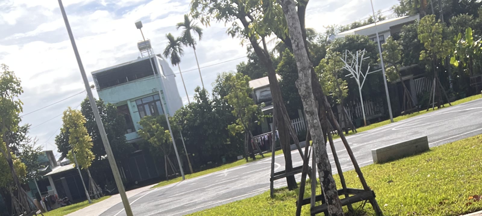 Công viên khu An Sơn Tam Kỳ, sân bóng rổ và hàng cây xanh mới trồng, nhà phố phía xa