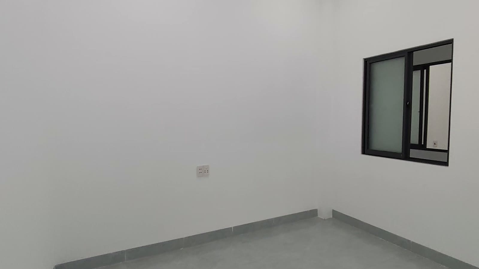 Phòng ngủ tường trắng có cửa sổ khung nhôm đen kính mờ, ổ điện chừa sẵn, nhà kiệt Trần Cao Vân Tam Kỳ