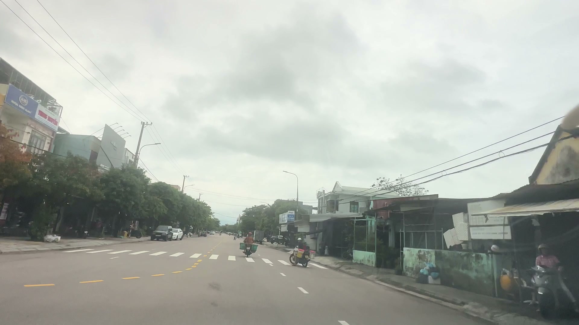 Ngã tư đông đúc trên đường Phan Châu Trinh khu An Sơn Tam Kỳ, xe máy ô tô qua lại, cửa hàng hai bên