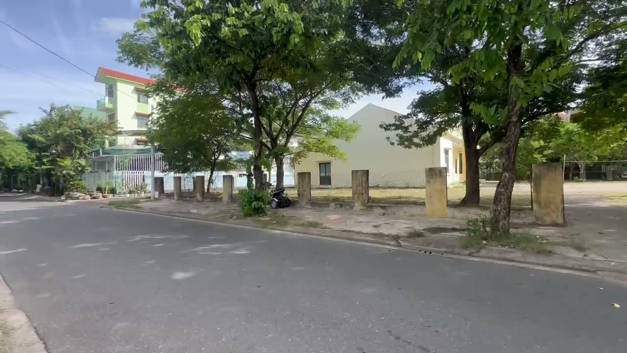 Mặt đường nhựa Nguyễn Công Trứ ở Tam Kỳ, lề đường rộng có hàng cây xanh, phía bên kia là sân nhà văn hoá khối phố
