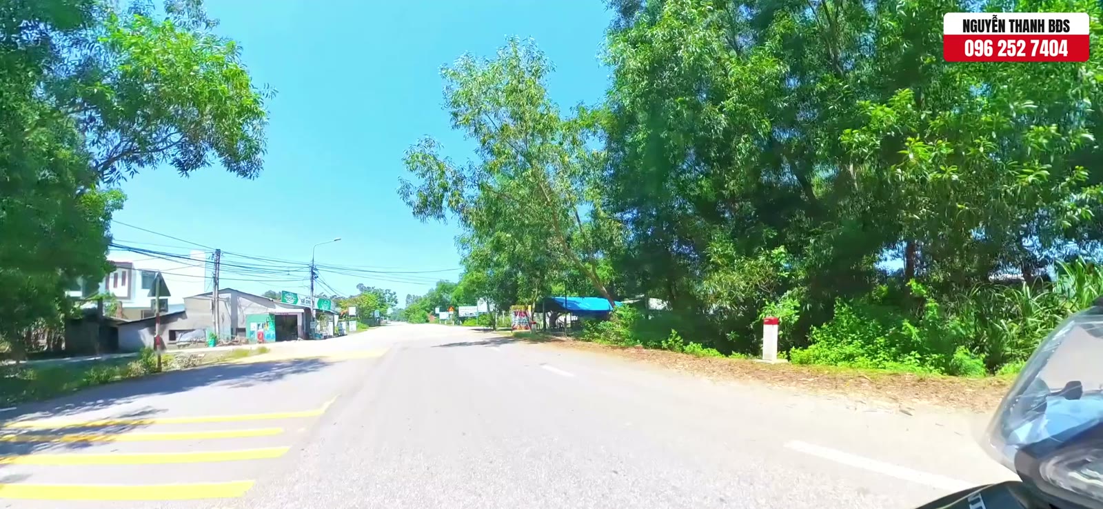 Đường Thanh Hoá đoạn trước khu dân cư 270 Quảng Phú, hai bên có nhà dân và hàng quán buôn bán, cây xanh ven đường