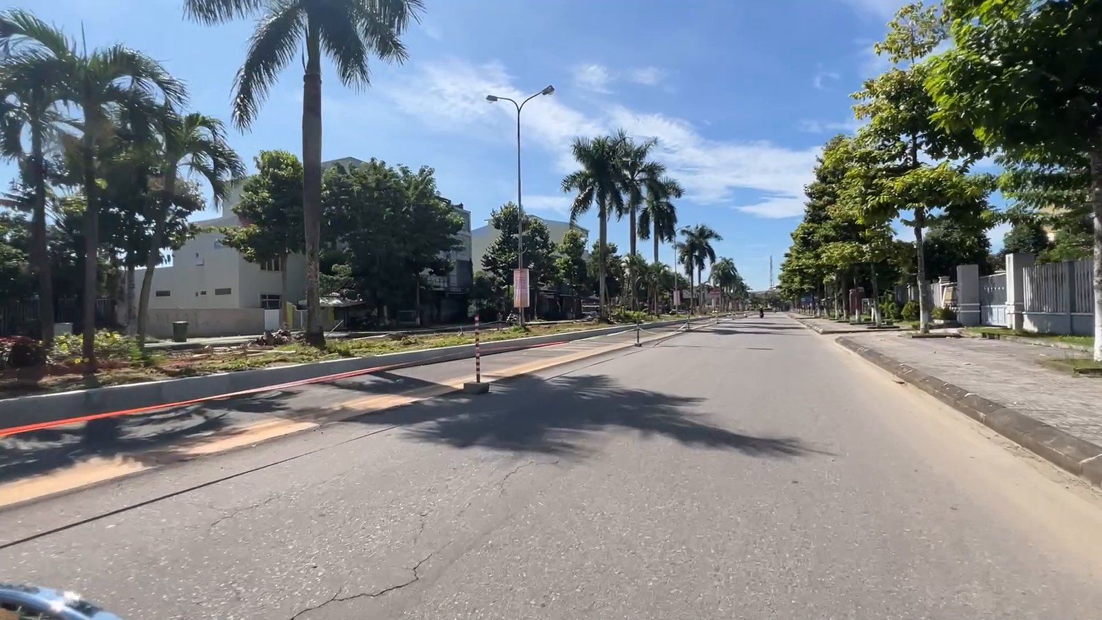 Đoạn đường Hùng Vương Tam Kỳ mặt nhựa còn mới, hàng cọ bên đường và trời nắng