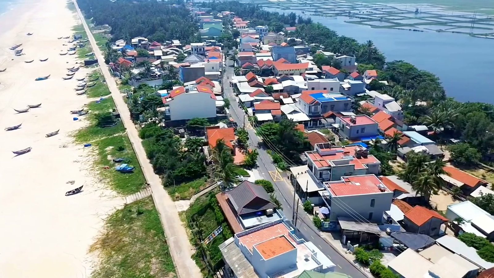 Làng Tam Thanh nằm sát bãi biển nhìn từ flycam, nhà mái ngói đỏ san sát