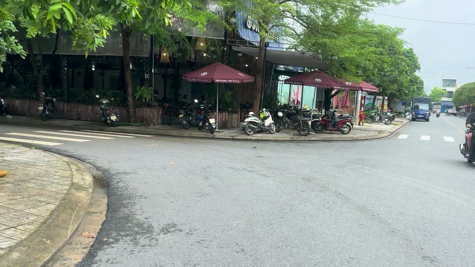Ngã ba Thái Phiên giao Phan Châu Trinh Tam Kỳ, góc đường có quán cà phê và xe máy đậu