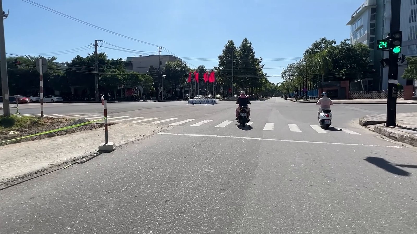 Ngã tư có đèn tín hiệu và vạch qua đường trên đường Hùng Vương Tam Kỳ, xe máy chạy bình thường