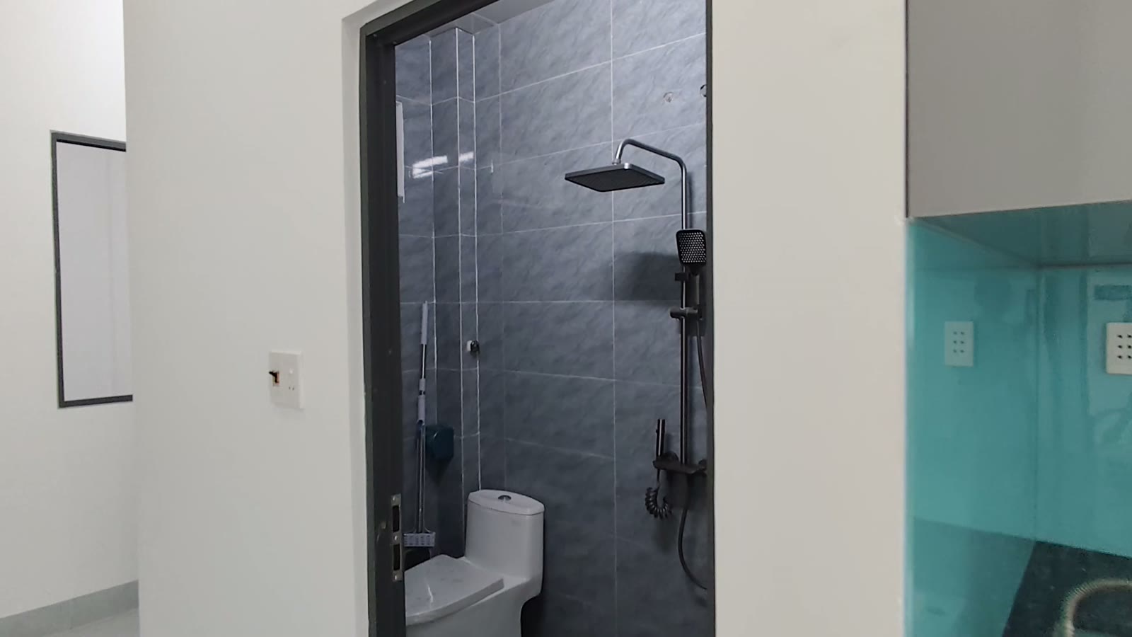 Nhà vệ sinh ốp gạch xám, sen tắm cây màu đen và bồn cầu trắng, nhà kiệt Trần Cao Vân Tam Kỳ