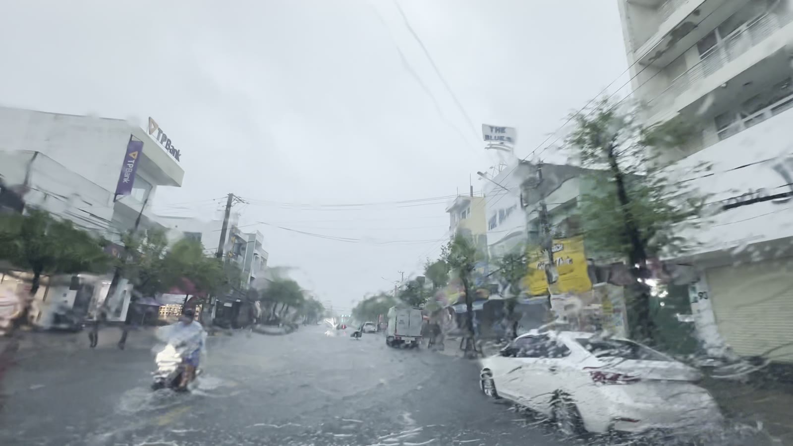 Nước đọng kín mặt đường Phan Châu Trinh Tam Kỳ sáng 8/10/2026, xe máy chạy qua rẽ nước thành hai luồng