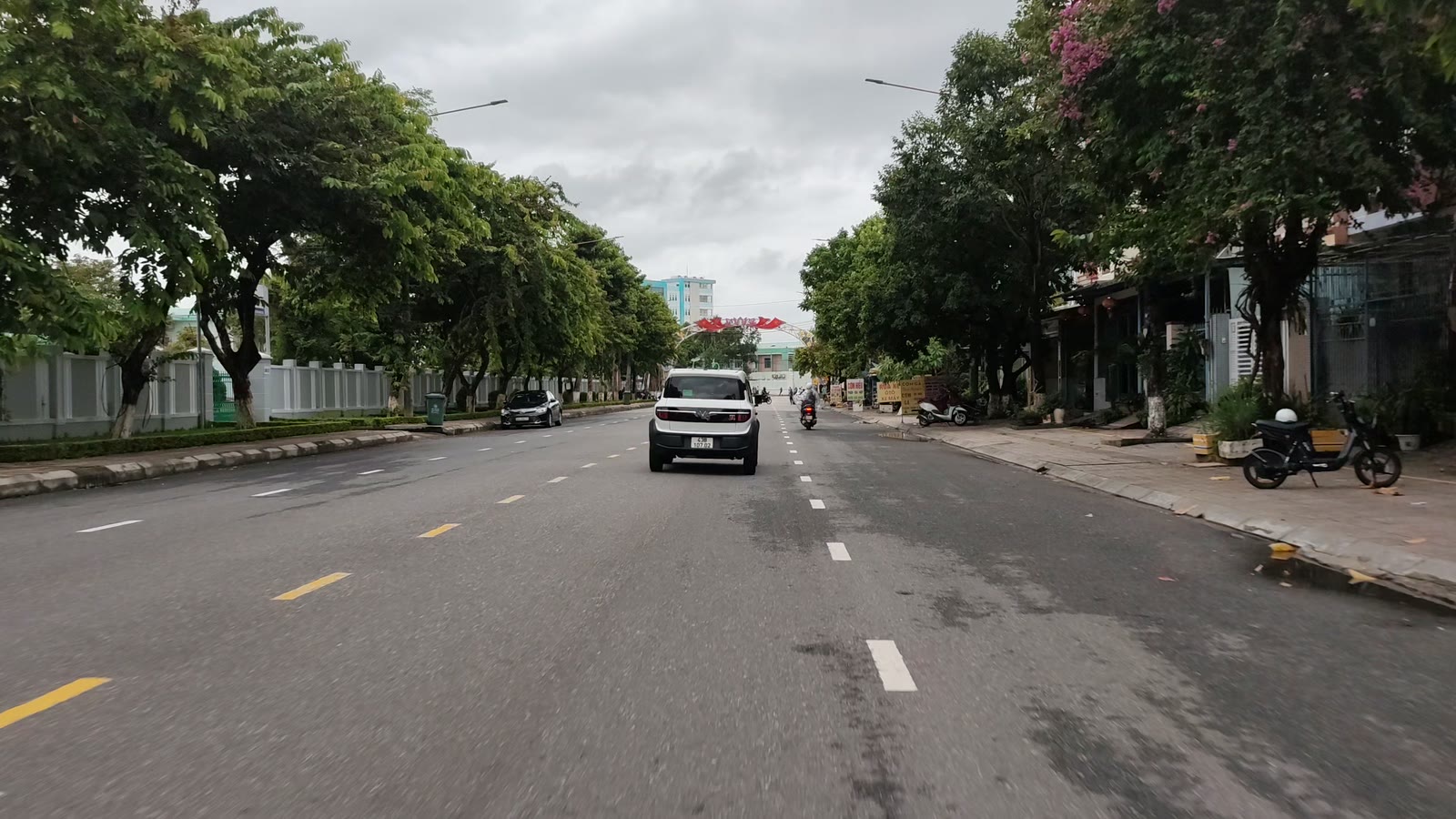 Phố buôn bán ở trung tâm Tam Kỳ, cửa hàng hai bên đường, xe đậu trước tiệm