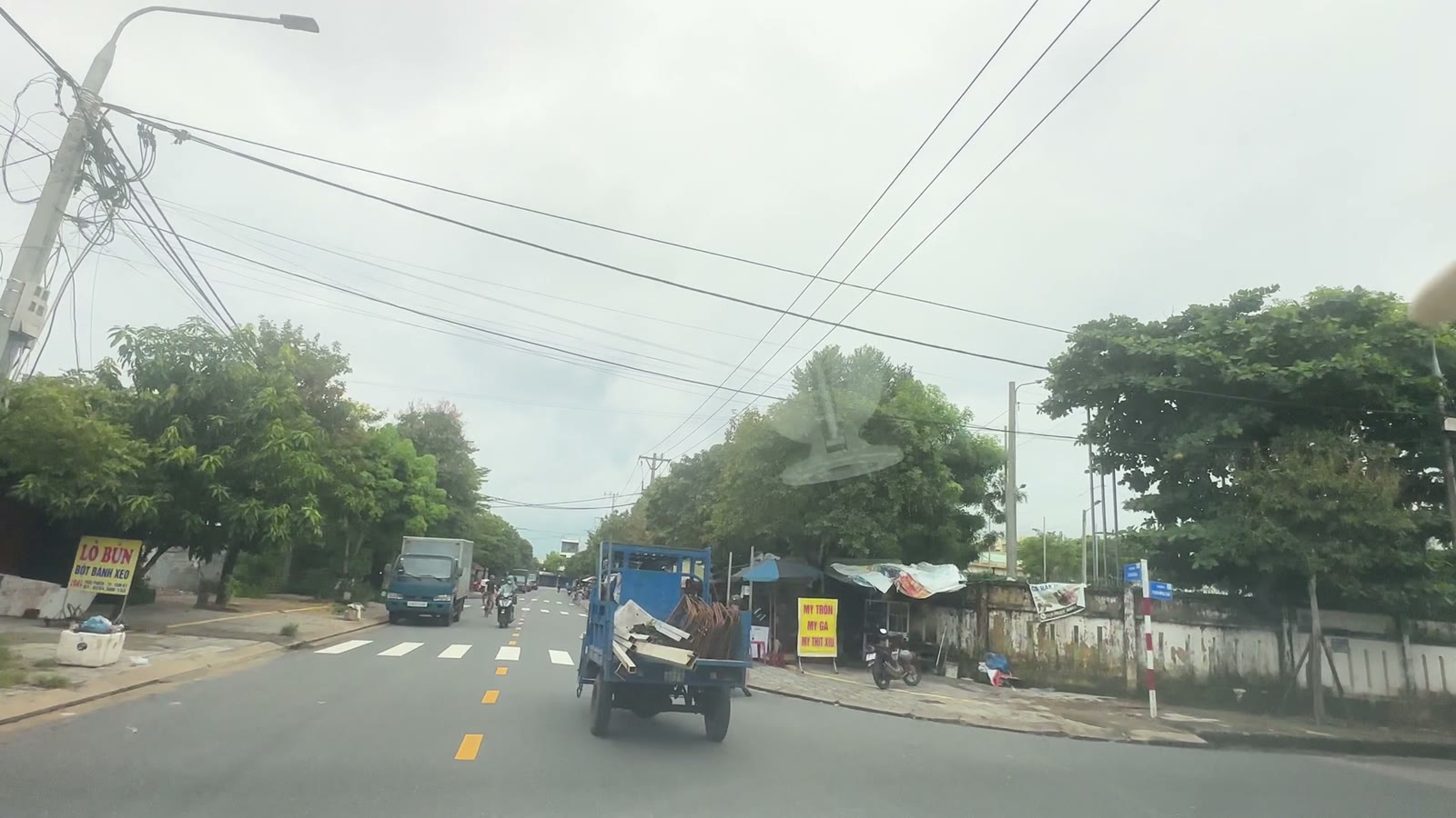 Dãy quán ăn sáng dọc đường Thái Phiên Tam Kỳ buổi sáng, xe tải và xe máy qua lại