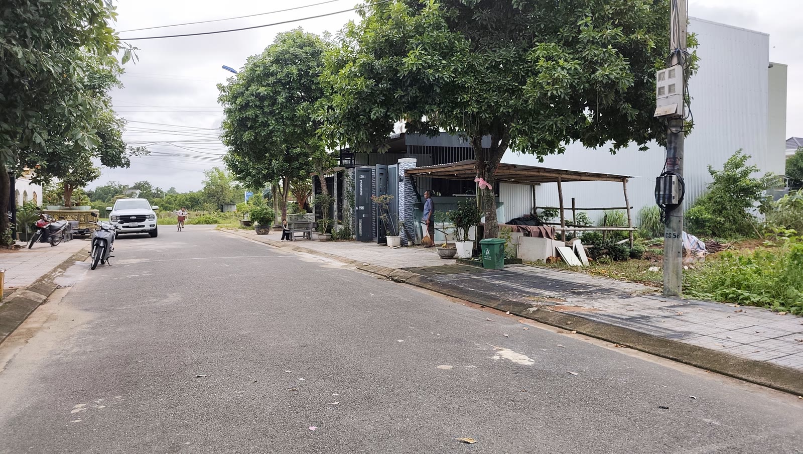 Đường nhựa trong khu dân cư Trường Xuân Tam Kỳ có vỉa hè lát gạch, cây xanh và ô tô đang chạy