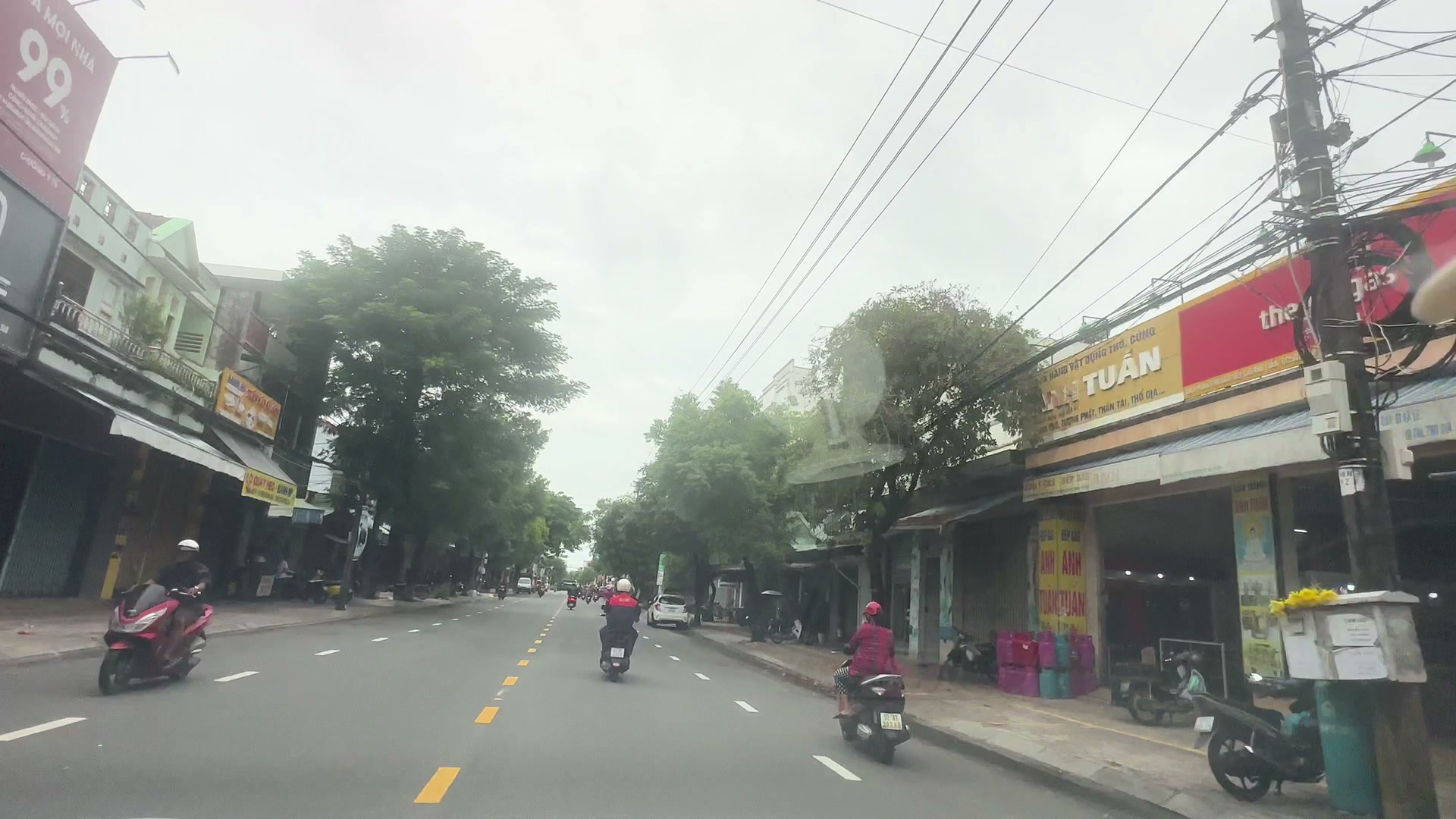 Dãy cửa hàng buôn bán sầm uất trên trục Phan Châu Trinh Tam Kỳ, biển hiệu nối nhau, xe đậu trước tiệm